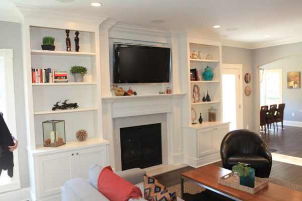 Custom Bookcases with open shelves surrounding the overmantel and cabinets below the counter