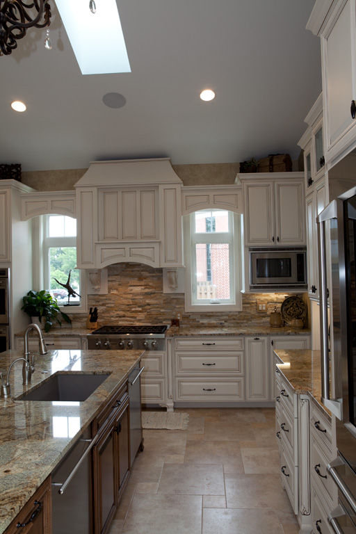 Custom hood over cook top with granite counters and stone back splash