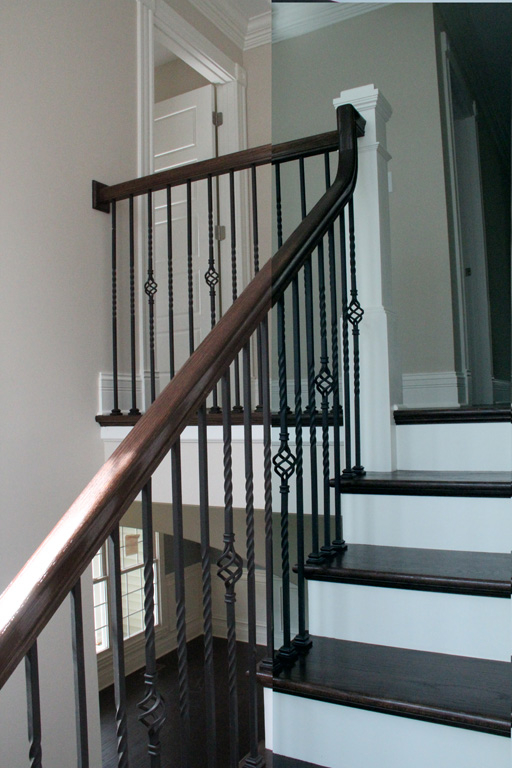 Stained treads. Balusters are wrought iron with a twist basket twist pattern