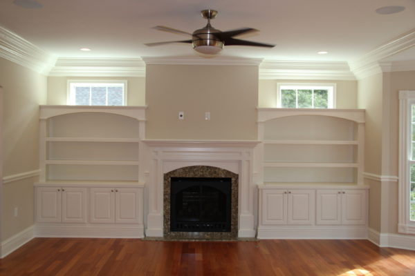 Custom painted Mantle with arched opening and granite surround.Arched open shelves above the counter with cabinets below. Transom windows above the bookcases