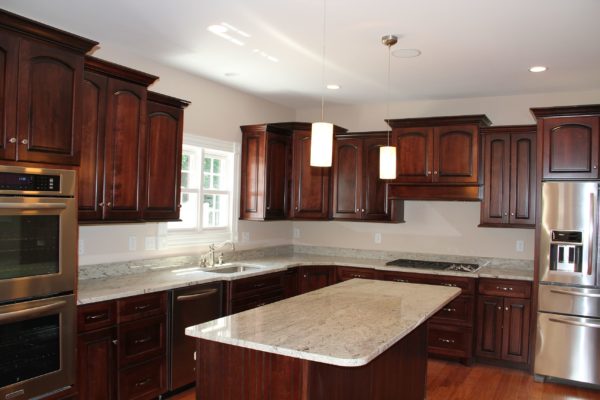 Stained cabinets and island with white granite counters